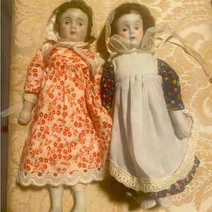 2 antique porcelain dolls / bonnets and pilgrim like dresses. Approx 12”